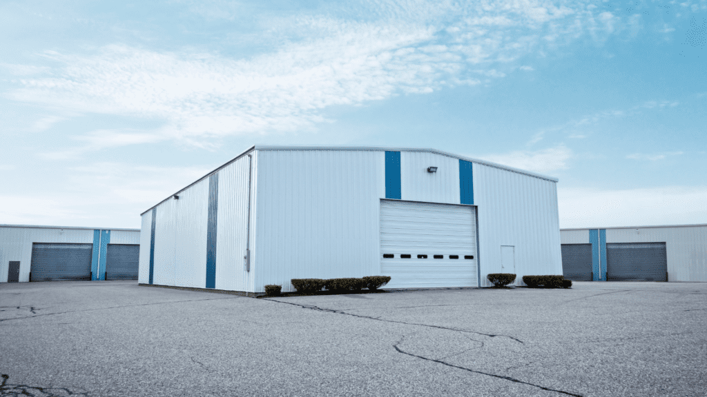 A prefabricated white and blue steel commercial building by Steel City, representing functional designs for Factory Sheds used n the Pakistani industrial sector.
